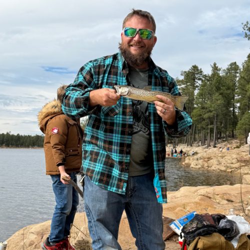 Chris holding a trout at a lake on the Mogollon Rim
